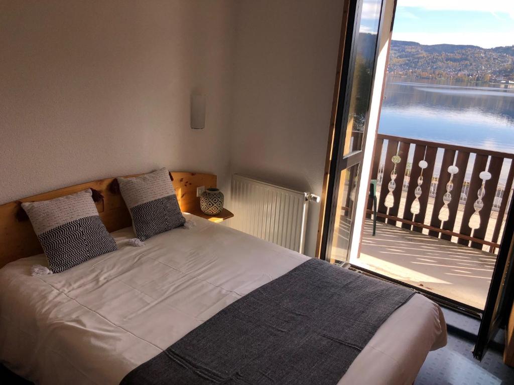 热拉梅Le Chalet au bord du lac的一间卧室设有一张床,享有阳台的景色