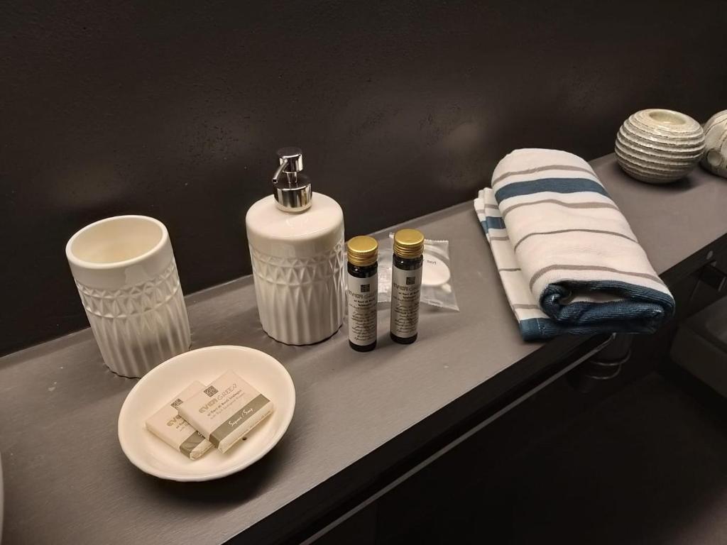 摩德纳Modena Charme Sant'Eufemia的浴室柜台提供2瓶毛巾