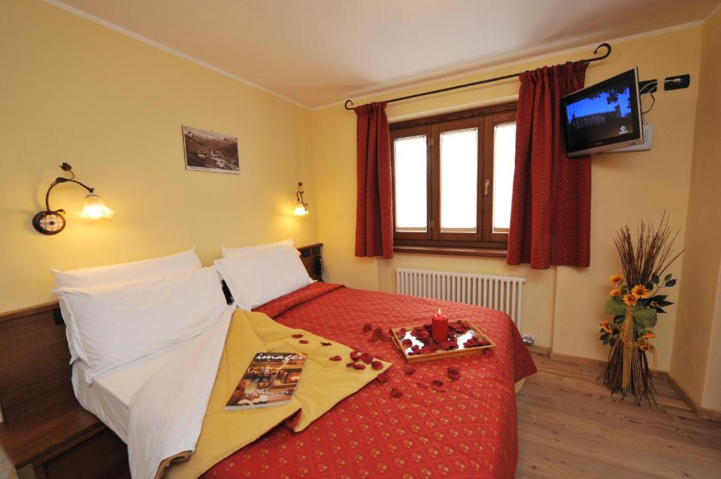 尚波吕克乐佩蒂特阿博丽酒店的一间卧室配有一张红色床罩的床