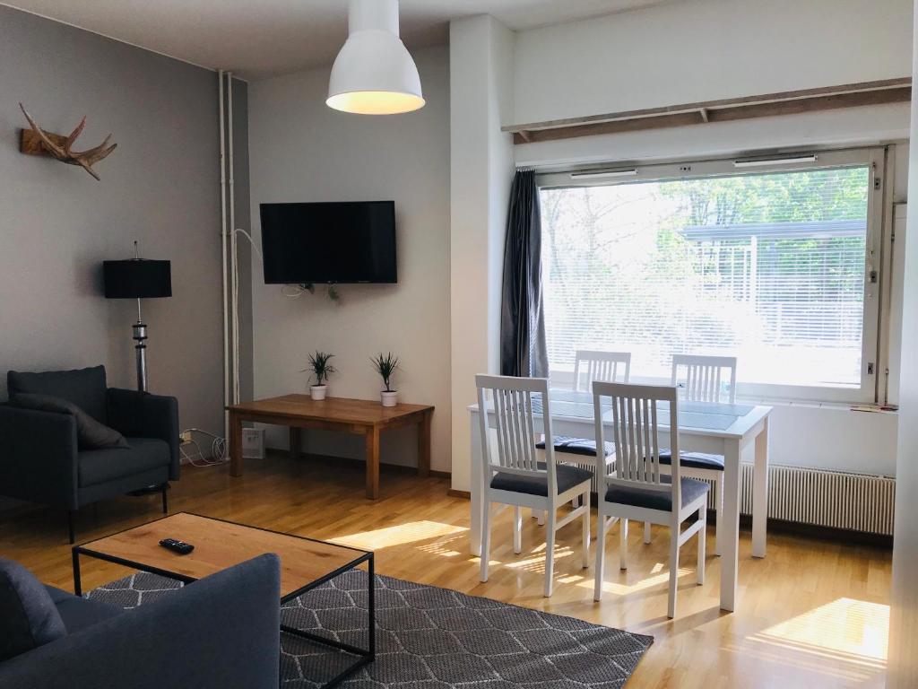 赫尔辛基Kamppi City Apartment的客厅设有餐桌和椅子