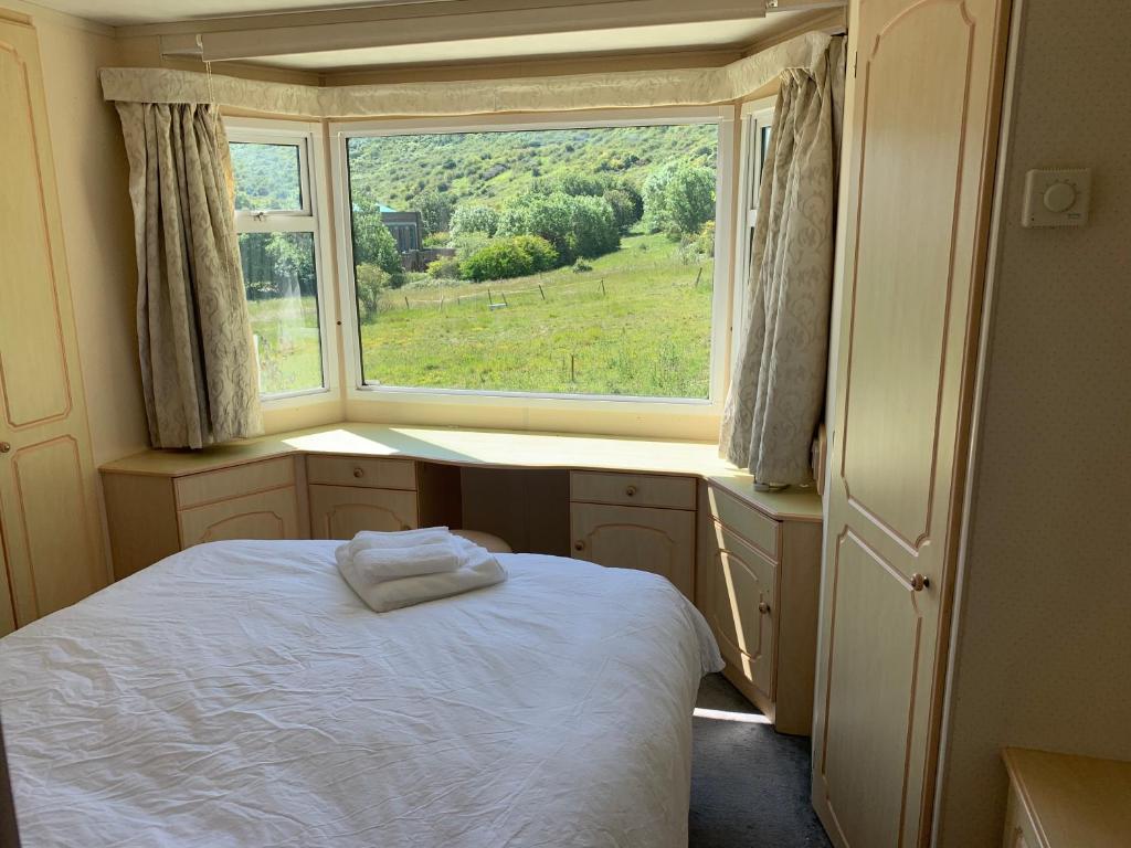 布莱顿霍夫Private Countryside Holiday Cabin 10 mins from Brighton的卧室在窗户前配有一张床
