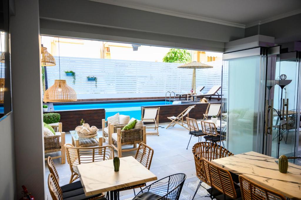 奥林匹亚基·阿克蒂Retro luxury rooms的一个带桌椅的庭院和一个游泳池