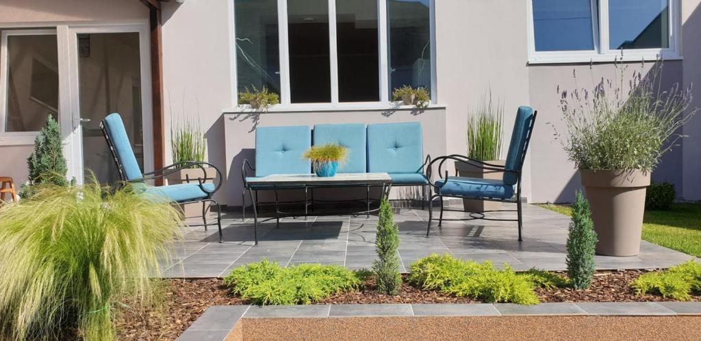 松博尔Sombor 19 Central Apartment的庭院配有蓝色的椅子和桌子