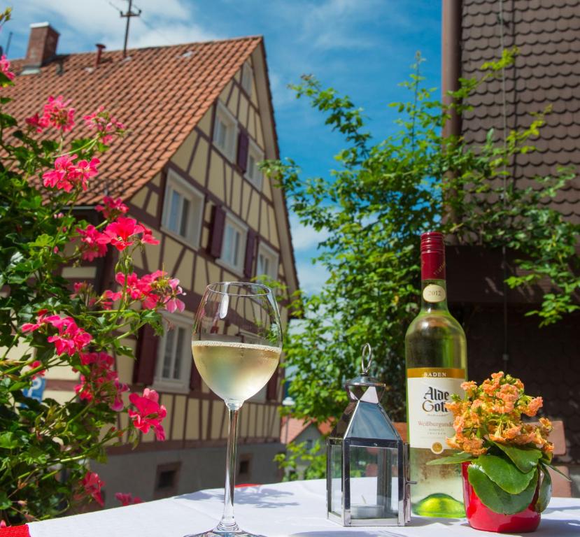 格恩斯巴赫Gästehaus Sonne的一瓶白葡萄酒和一张桌子上的一杯