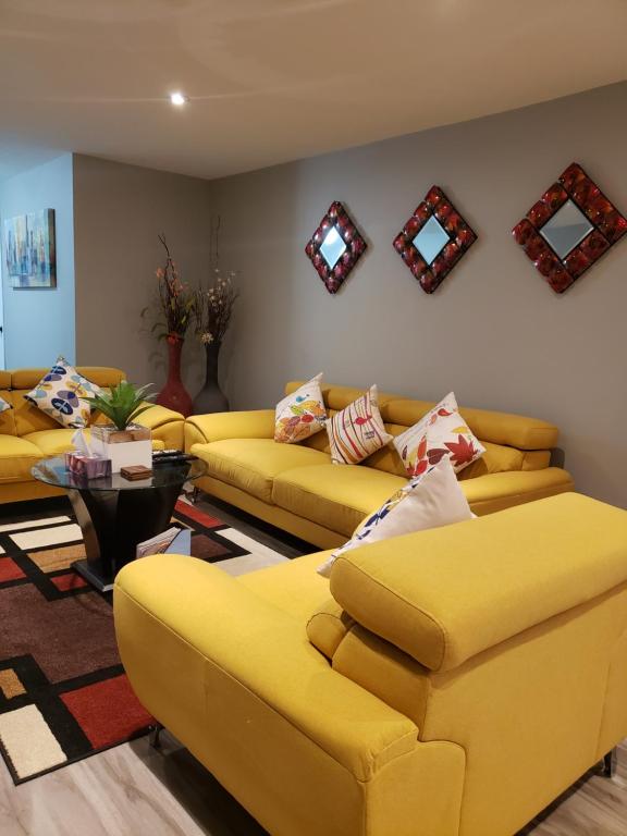 Stratford瑟仁迪勃住宿加早餐旅馆的客厅配有黄色的沙发和桌子
