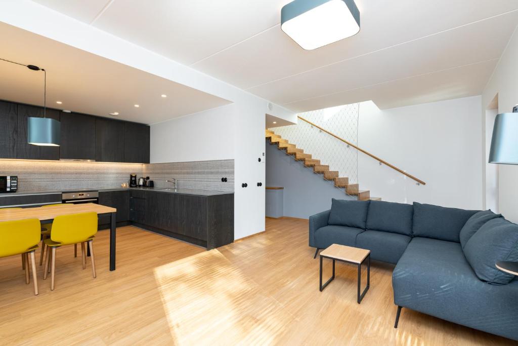 塔林Self-check-in 3 bedroom apartment with sauna and balconies的客厅以及带蓝色沙发和黄色椅子的厨房。