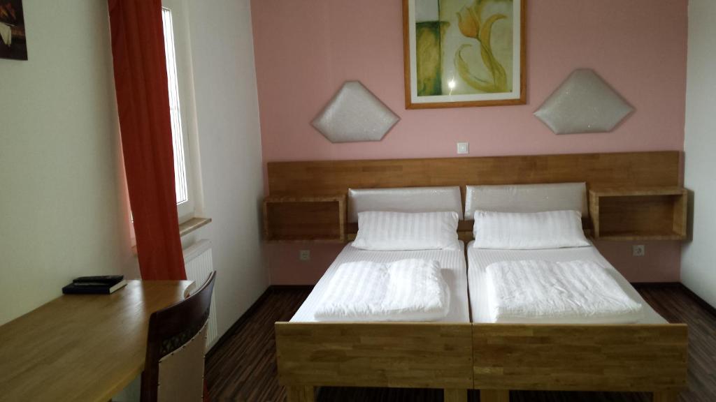 韦茨拉尔拉特扎酒店的一间卧室配有两张床、一张桌子和一张桌子