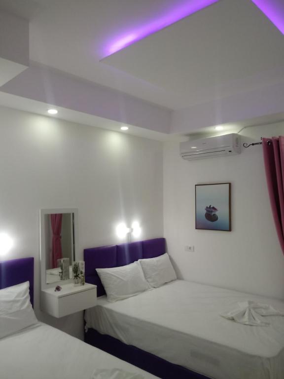 帕拉利亚卡泰里尼斯B&A Paralia的一间卧室配有两张床和紫色灯