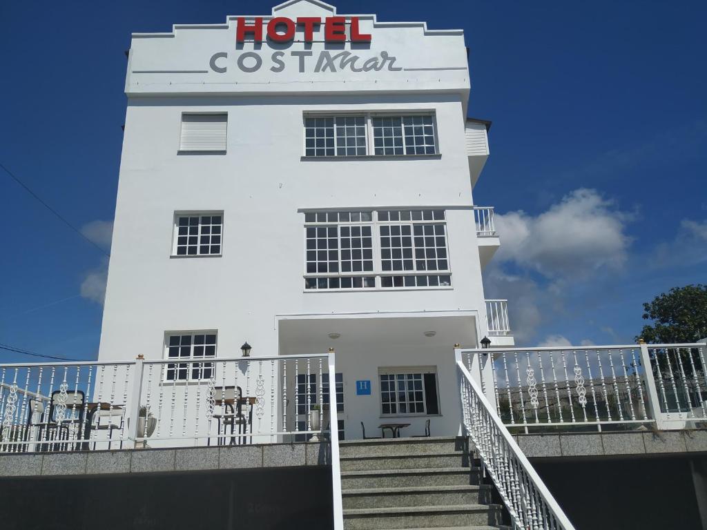 桑亨霍Hotel costa mar的白色的建筑,上面有标志