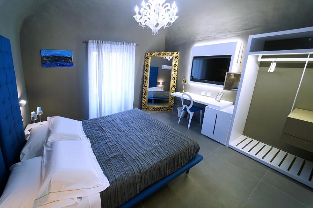卡塔尼亚埃特纳套房旅馆的一间卧室配有床、镜子和水槽