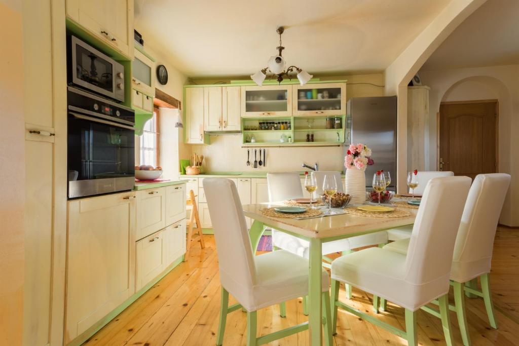 乌马格Casa Romantica的厨房配有桌子和白色椅子