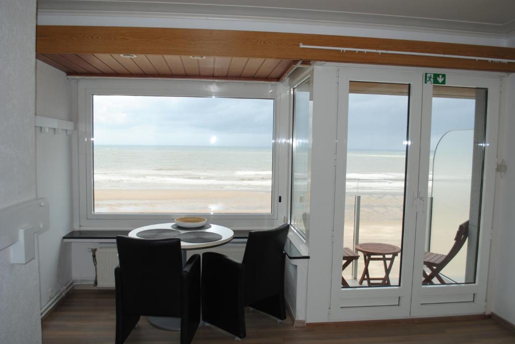 奥斯坦德De Zee的一间设有桌子并享有海滩美景的用餐室