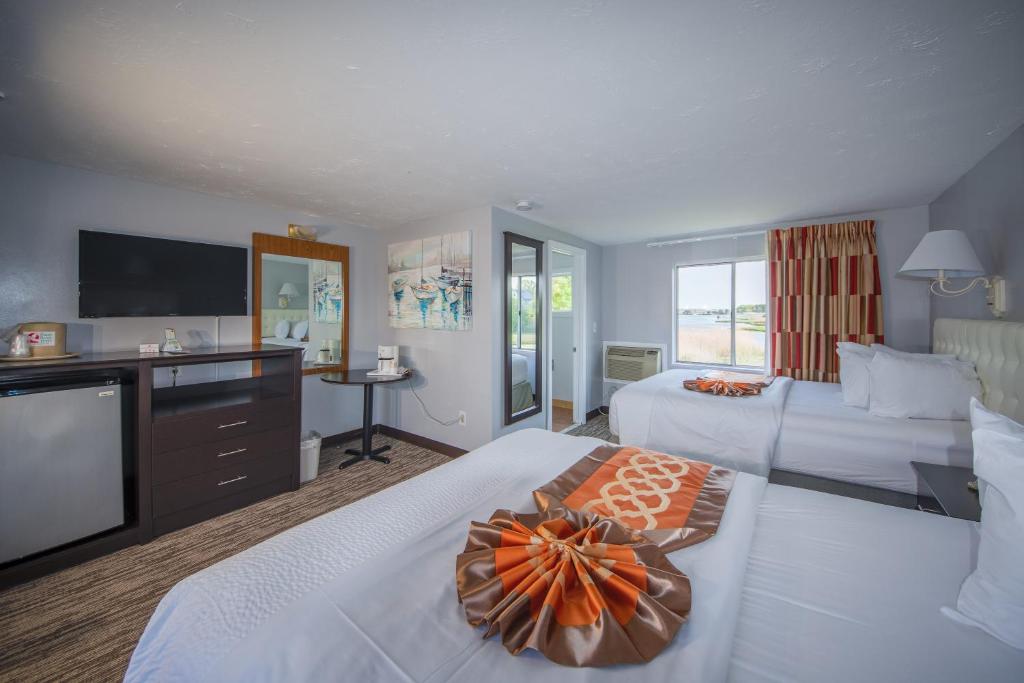 西雅茅斯Cape Sands Inn的酒店客房设有两张床和一台平面电视。