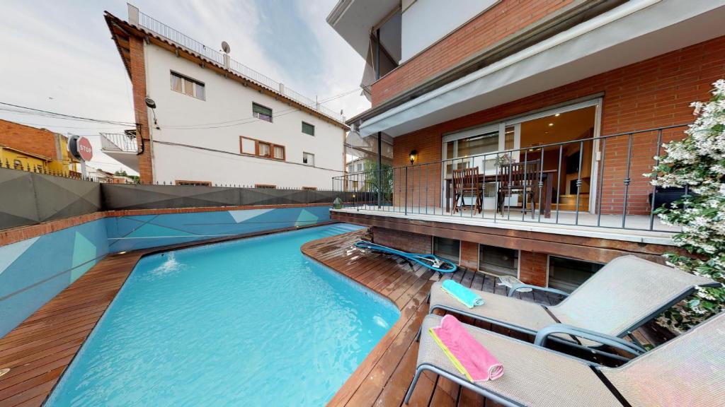 班约莱斯HOUSE OF JOY , CASA EN BANYOLES的一个带2把躺椅的游泳池以及1栋房子