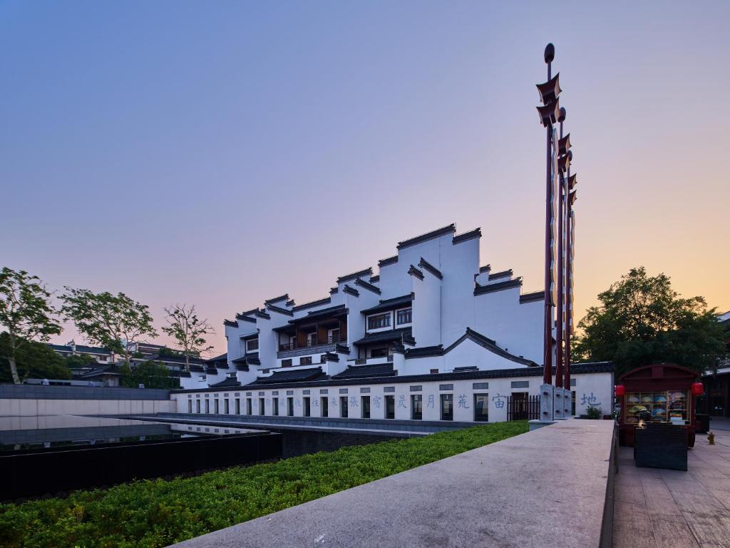 南京南京夜泊秦淮君亭酒店大戏院店的一条白色的大建筑,坐在人行道上