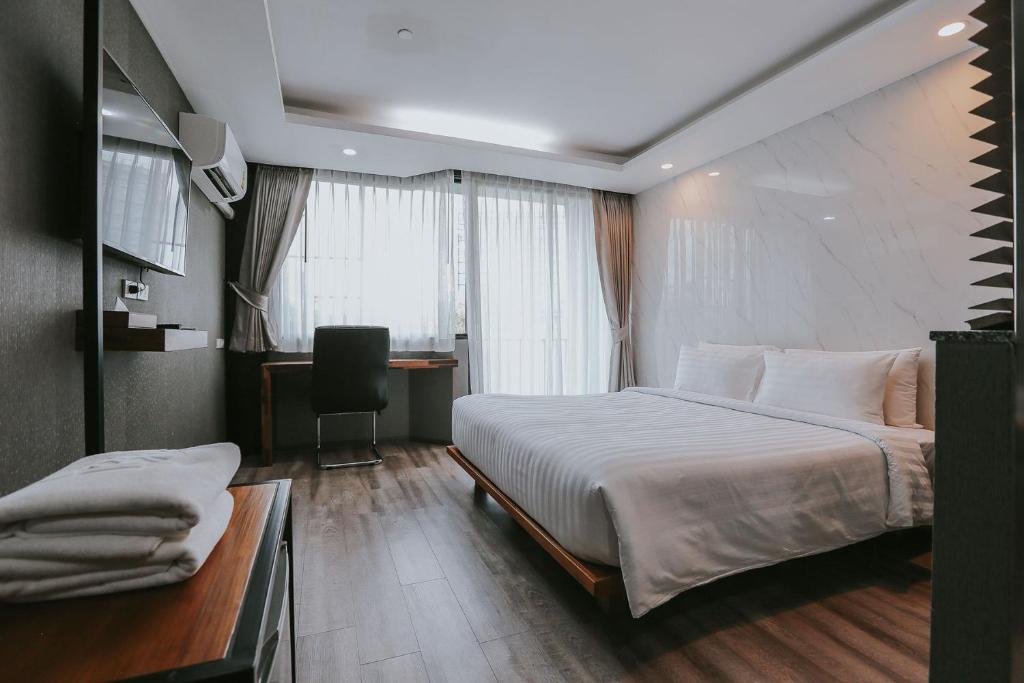 曼谷Bangkok City Link Hotel的酒店客房设有一张大床和一张书桌。