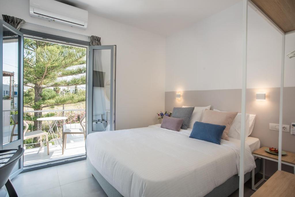 帕罗奇亚Nautilus Apartments-Suites的一间带一张白色大床的卧室和一个阳台