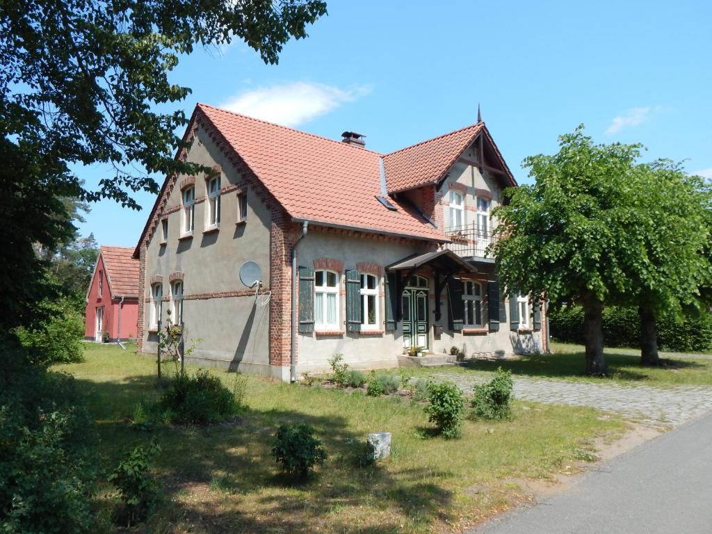 Alt JabelFerienhaus am Wald mit Klavier, Holzofen, Sauna的一座红色屋顶的房子和一棵树