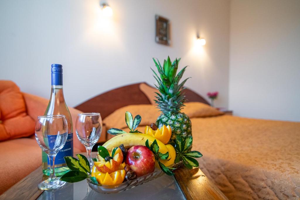 瓦尔纳阿达莫酒店的一张桌子,上面放着一碗水果和一瓶葡萄酒