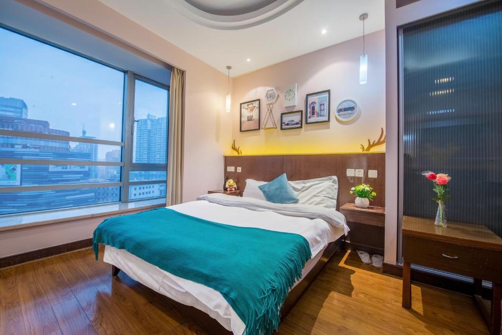 上海上海新时空家荣酒店公寓中山公园分店的一间卧室设有一张大床和一个大窗户