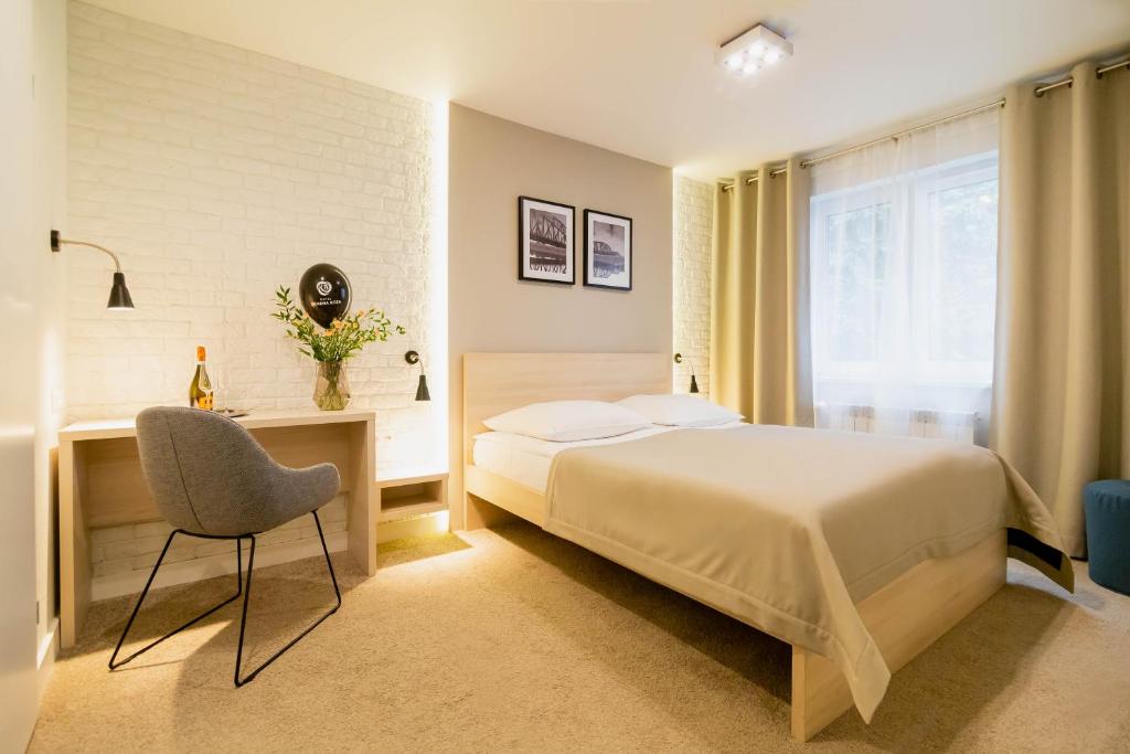 托伦萨那洛扎酒店的一间卧室配有一张床、一张桌子和一把椅子