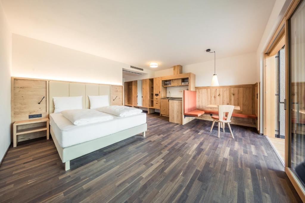 卡尔达罗Weingut Moser Apartments的一间卧室配有一张床、一张桌子和一张桌子
