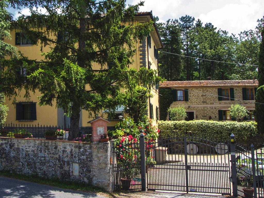 斯卡尔佩里亚Alloggio Villa Manini的前面有栅栏的黄色房子