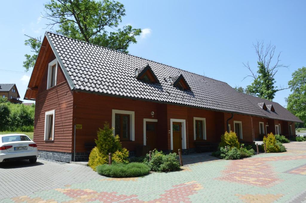 Dolní MoraviceApartmány Divoký Anděl的一间棕色的房子,前面有一辆汽车