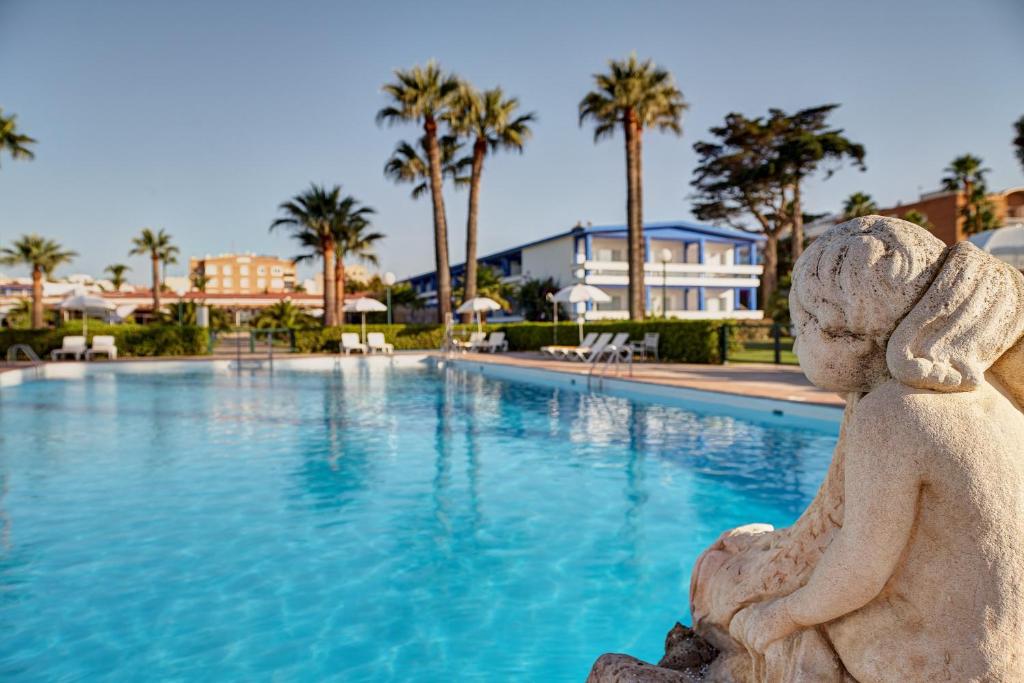 贝尼卡洛贝尼卡洛旅馆的坐在游泳池前的小女孩雕像