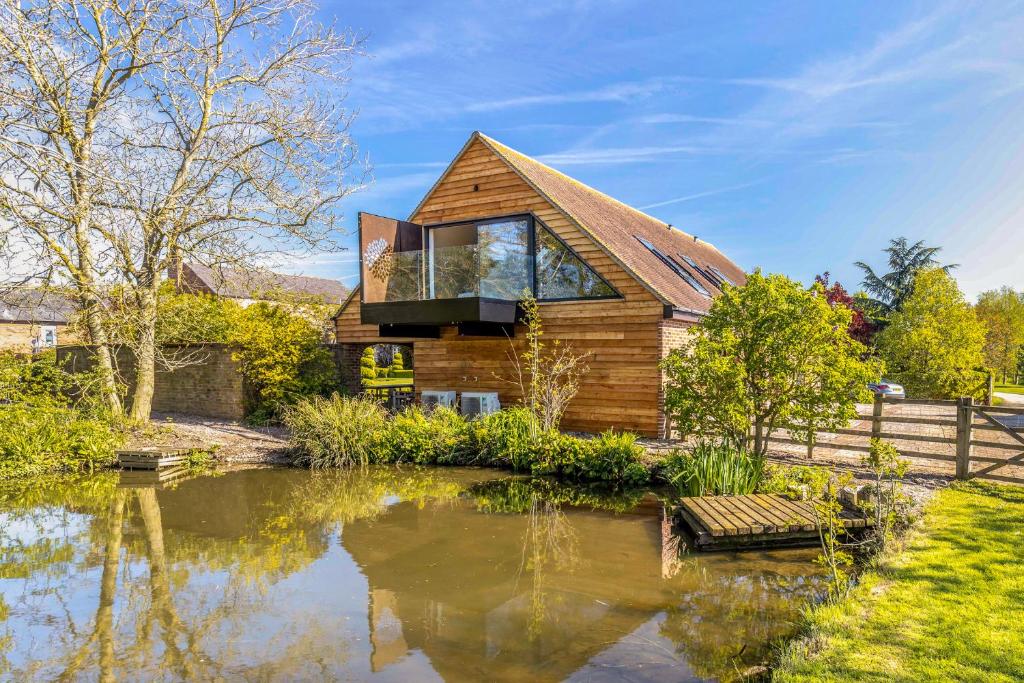 ClipstonThe Loft : Luxury Countryside Retreat for Family & Friends的一座木屋,前面设有一个池塘