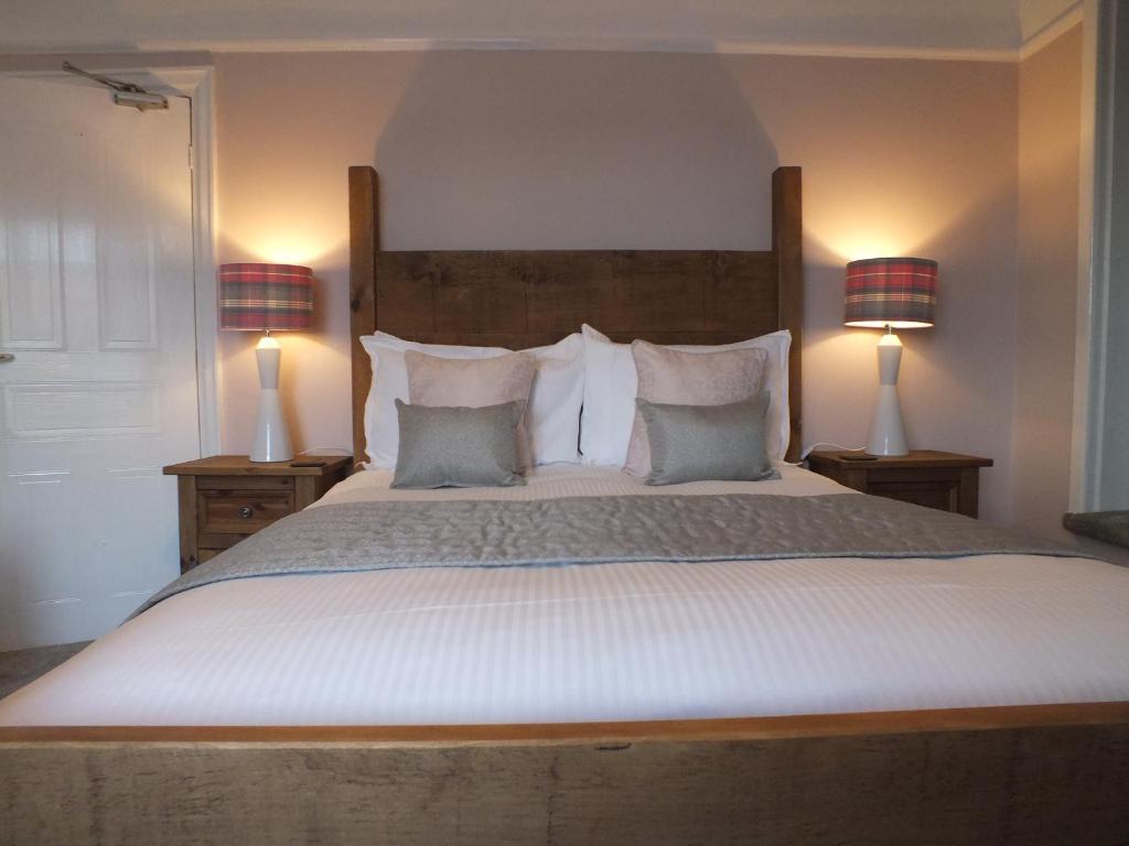 Cracoe德文郡力推酒店的一间卧室配有一张带两盏灯的大型白色床。