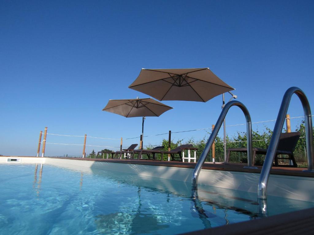 科斯蒂廖莱达斯蒂拉吉比安娜B&B酒店的游泳池上方设有遮阳伞
