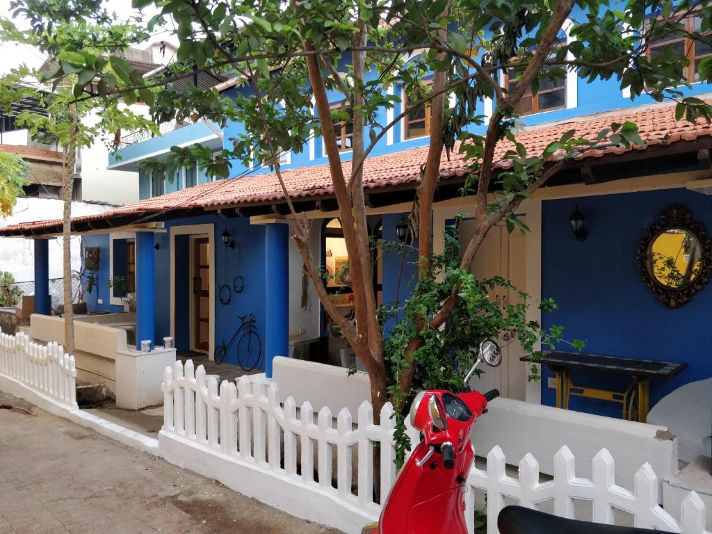 帕纳吉The White Balcao的白色栅栏和红色摩托车的蓝色房子