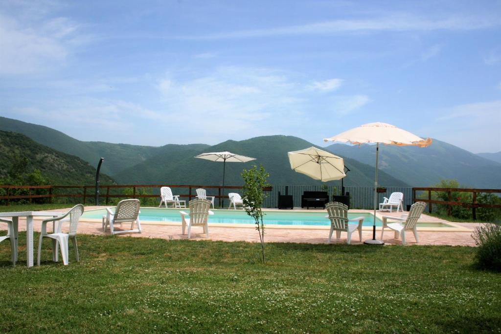 MeggianoAgriturismo Tre Monti的一组椅子和遮阳伞,位于游泳池旁