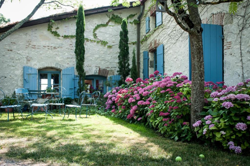 洛特河畔的维伦纽夫莱斯胡谷特斯酒店的一座鲜花盛开、桌椅的房子
