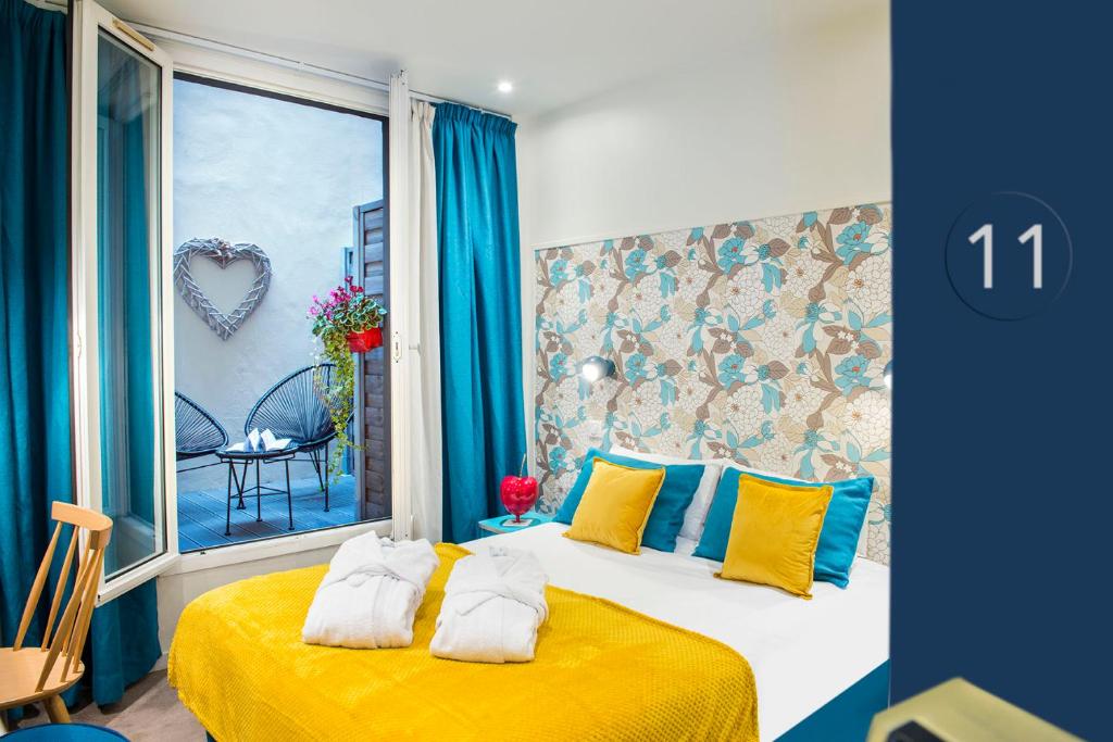 巴黎波西米亚别墅酒店的一间卧室配有黄色和蓝色枕头的床