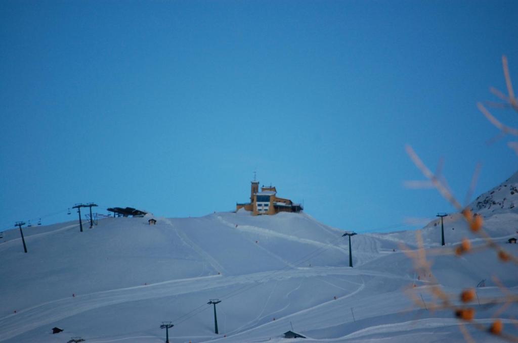 塞斯特雷塔纳德拉尔普酒店的一座雪覆盖的山丘,上面有一座房子