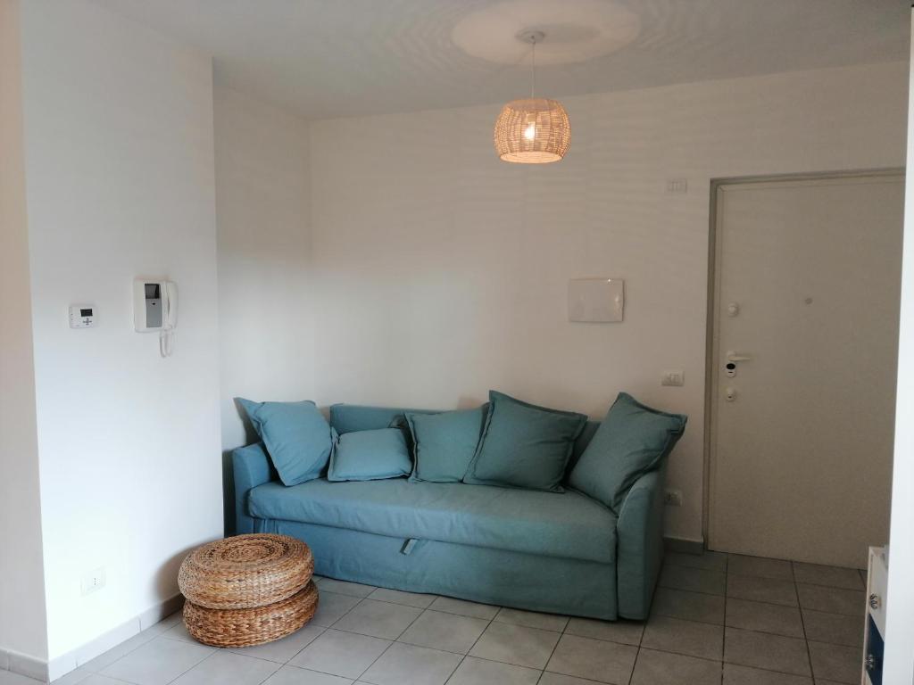 弗雷杰内monolocale Fregene via Agropoli的客厅配有一张蓝色的沙发,配有一张桌子