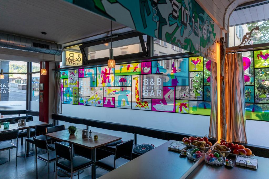 卢塞恩Bettstatt-Neustadt的餐厅设有桌椅和色彩缤纷的墙壁
