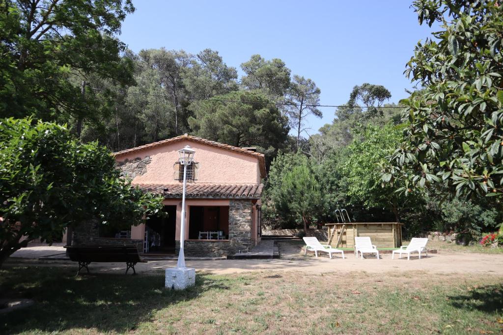 圣苏珊娜Masia Can Ninot的院子里的房屋,配有白色椅子和烧烤架