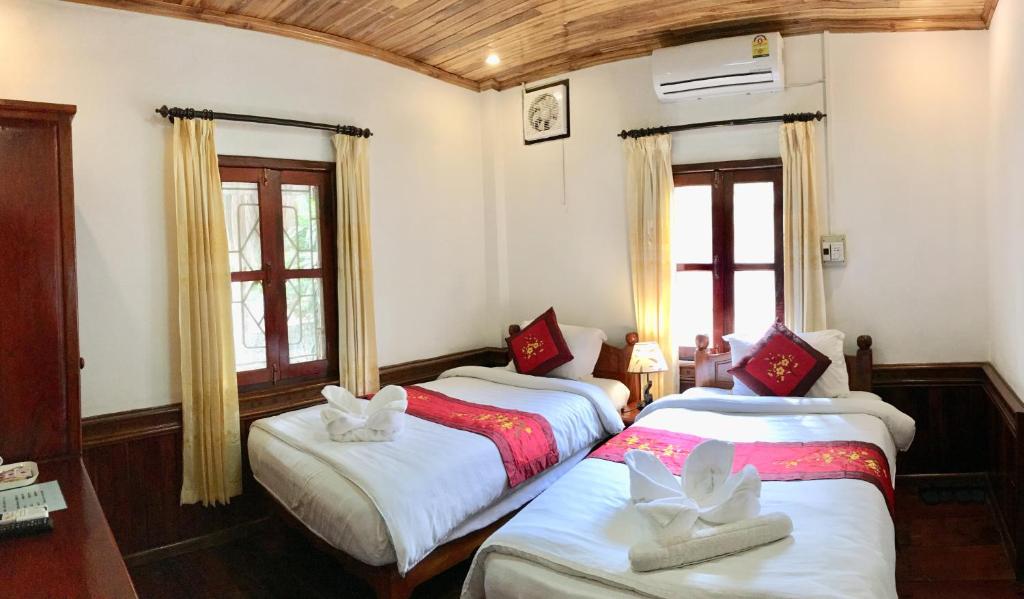 琅勃拉邦维拉凡宫旅馆的带2扇窗户的客房内的2张床
