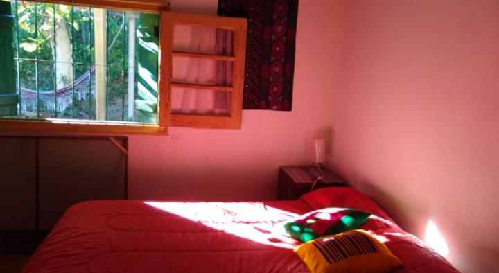 里奥塞瓦约斯Habitación en Casa Las Dos Nenas的一间卧室设有红色的床和窗户。