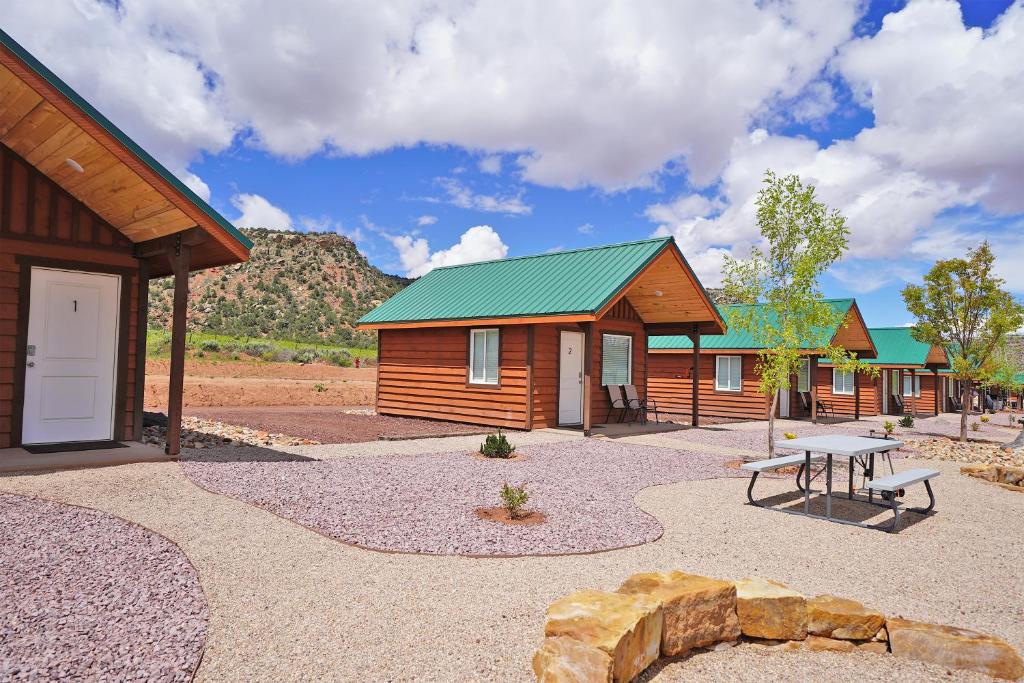 Apple ValleyGooseberry Lodges Zion National Park Area的一组小木屋,配有野餐桌和长凳