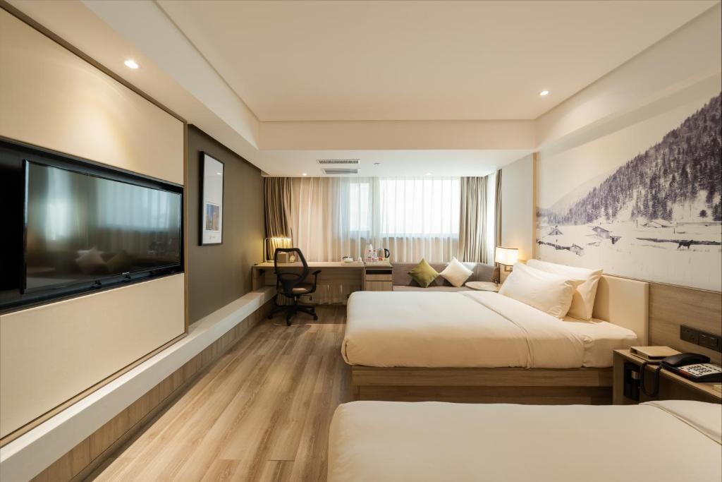 哈尔滨亚朵酒店(哈尔滨博物馆店)的酒店客房设有两张床和一台平面电视。