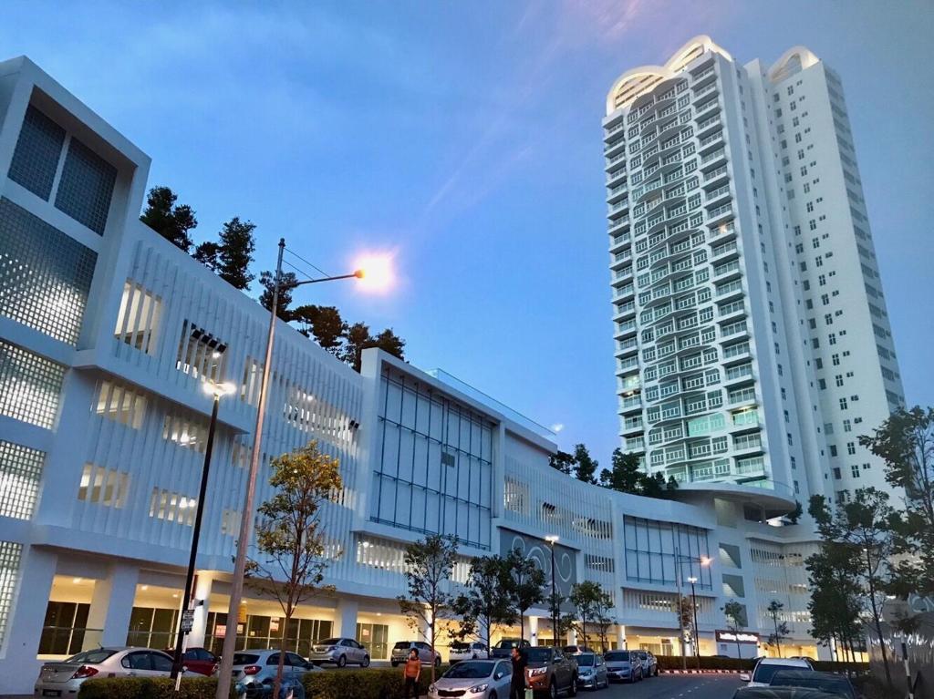 峇六拜Southbay Plaza Condominium的停车场内停放汽车的大型建筑