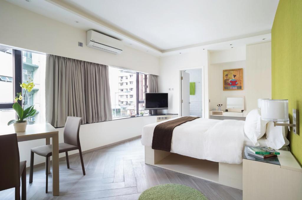 香港逸东轩住寓(山村道)的酒店客房配有一张床、一张书桌和一台电视。