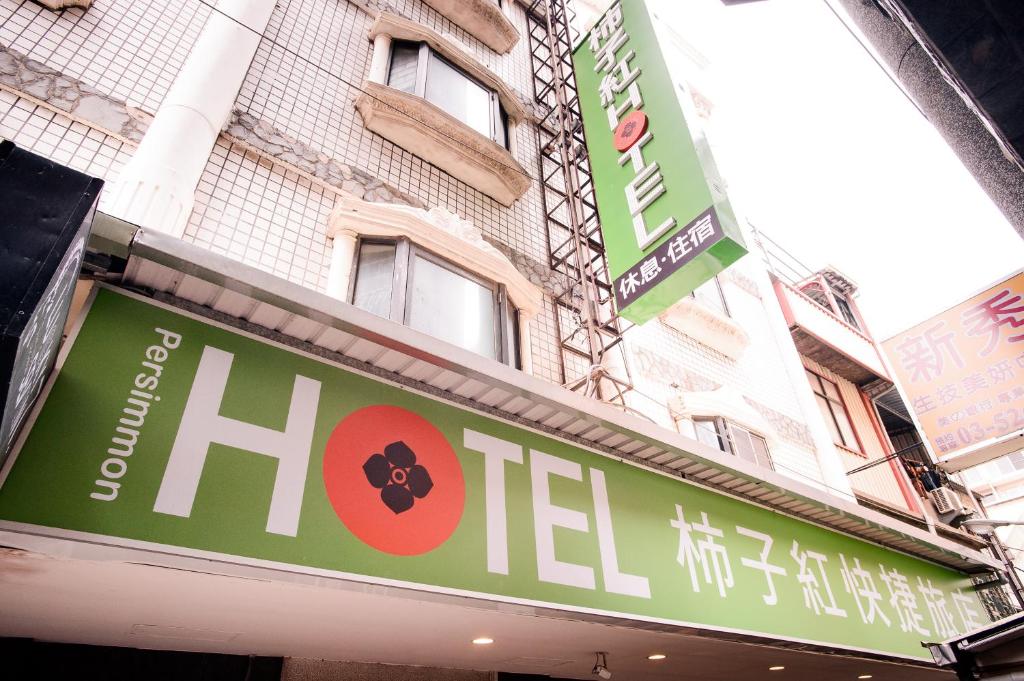 新竹柿子红快捷旅店的大楼前的酒店标志