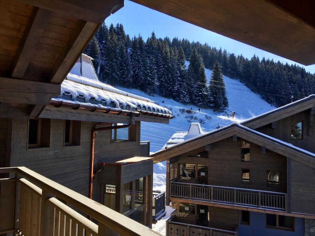普拉波特尔les 7 laux immobilier chalet E的从雪覆盖的树木的滑雪小屋阳台上可欣赏到风景
