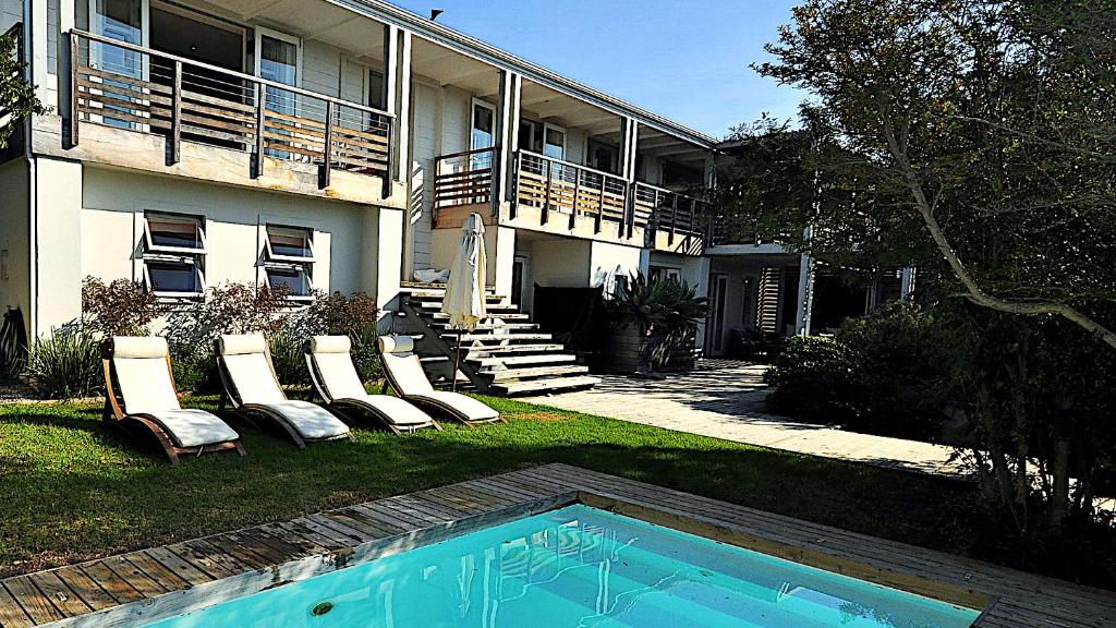 普利登堡湾Dassen Island 61的一座带椅子的房子和一个庭院内的游泳池