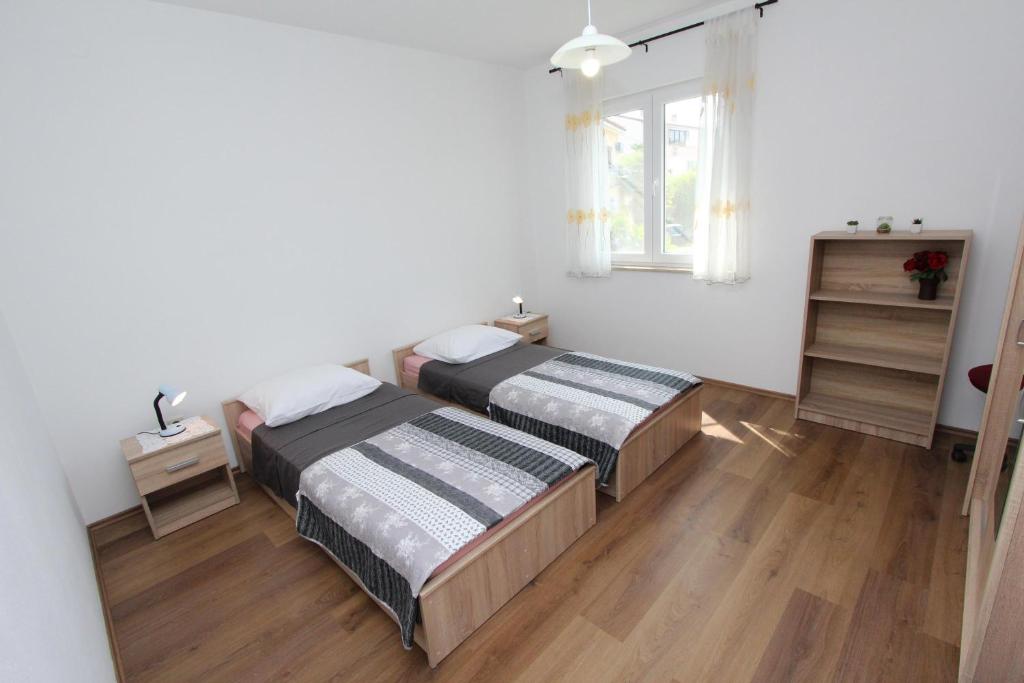 罗维尼迪娜公寓的一间卧室设有两张床和窗户。
